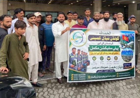 Workers and families gathered with the selection banner outside the terminal